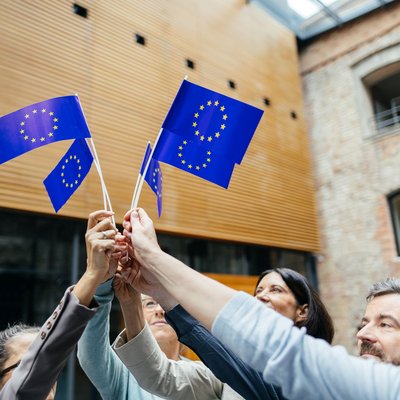 Menschen halten gemeinsam Europafahnen in die Luft.
