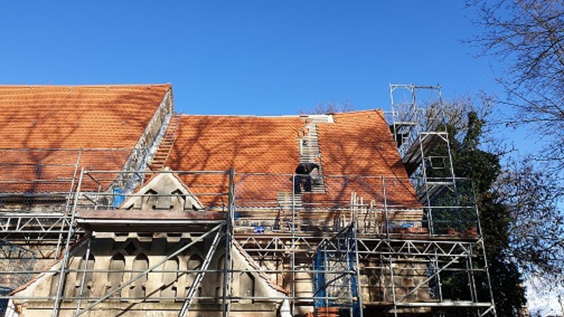 Hier sieht man, wie im Zuge der Sanierung der Rehfelder Dorfkirche das Dach neu gedeckt wird.